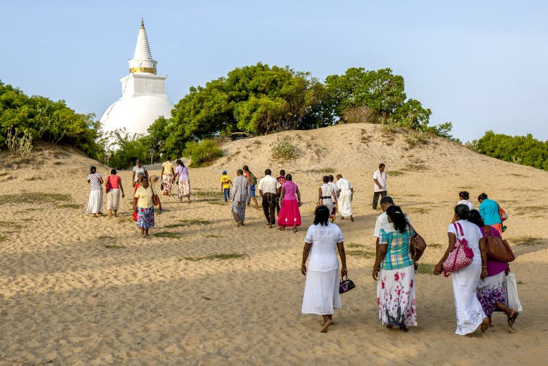 Los peregrinos budistas caminan hacia el stupa en la playa en Pottuvil en Sri Lanka foto de archivo Los peregrinos budistas caminan hacia el stupa en la playa en Pottuvil en Sri Lanka foto de archivo