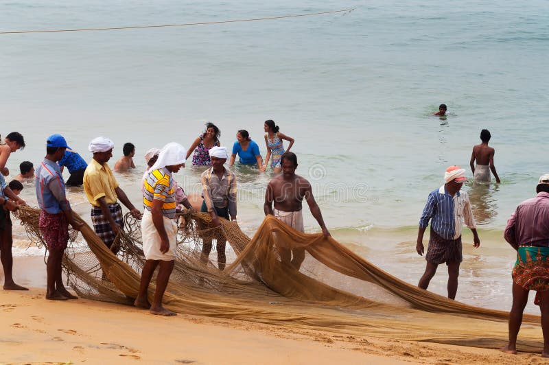 Los pescadores son tirón su red de pesca en la playa de Samudra en Kovalam fotografía de archivo Los pescadores son tirón su red de pesca en la playa de Samudra en Kovalam fotografía de archivo
