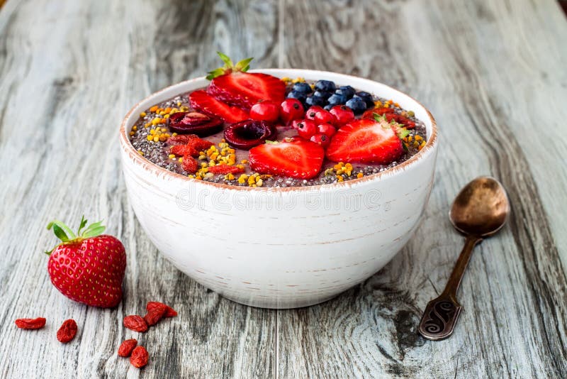 Los smoothies de los superfoods del desayuno de Acai ruedan con las semillas del chia, el polen de la abeja, los desmoches de la foto de archivo libre de regalías Los smoothies de los superfoods del desayuno de Acai ruedan con las semillas del chia, el polen de la abeja, los desmoches de la foto de archivo libre de regalías