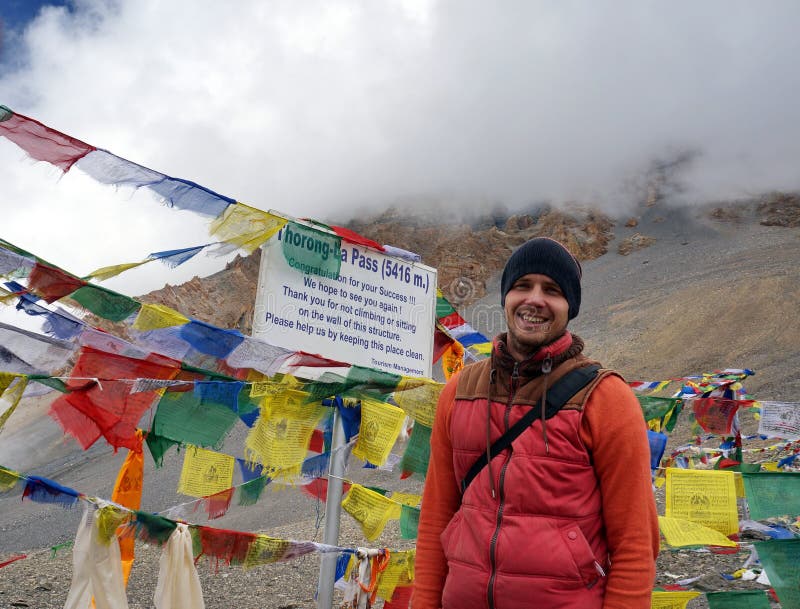 Los soportes turísticos al lado del signo positivo en el Thorong-La pasan los 5416m, el paso más alto del mundo imágenes de archivo libres de regalías Los soportes turísticos al lado del signo positivo en el Thorong-La pasan los 5416m, el paso más alto del mundo imágenes de archivo libres de regalías
