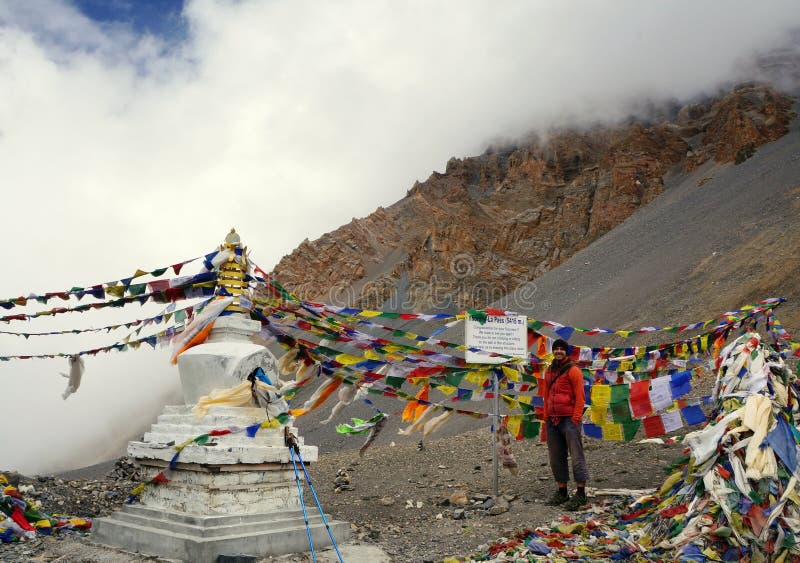 Los soportes turísticos sonrientes cerca de una muestra en el top del Thorong-La pasan himalaya nepal fotografía de archivo Los soportes turísticos sonrientes cerca de una muestra en el top del Thorong-La pasan himalaya nepal fotografía de archivo