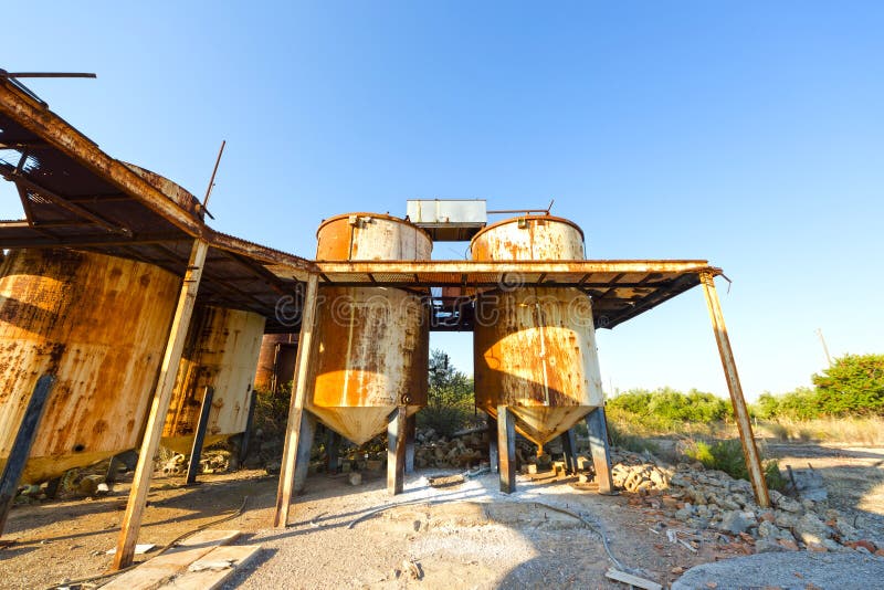 View of old, rusty storage tanks in an abandoned industrial unit in Greece. View of old, rusty storage tanks in an abandoned industrial unit in Greece.