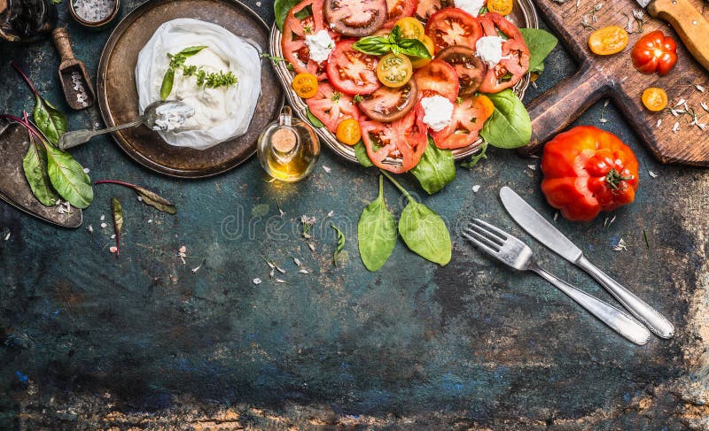 Los tomates y la ensalada de la mozzarella, preparación en oscuridad envejecieron el fondo rústico, visión superior Almuerzo ital imagen de archivo libre de regalías Los tomates y la ensalada de la mozzarella, preparación en oscuridad envejecieron el fondo rústico, visión superior Almuerzo ital imagen de archivo libre de regalías