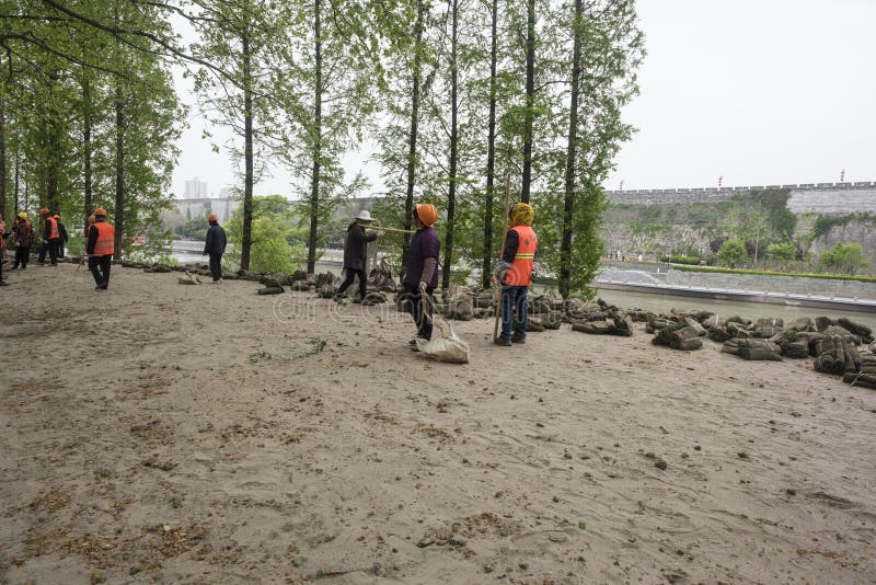 Los trabajadores del jardín plantaron la hierba en el río del qinhuai foto de archivo Los trabajadores del jardín plantaron la hierba en el río del qinhuai foto de archivo