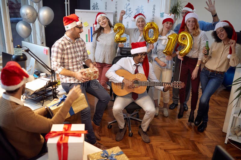 Los trabajadores felices del negocio tienen la diversión y baile en el sombrero de Papá Noel en el partido de Navidad juntos fotografía de archivo libre de regalías Los trabajadores felices del negocio tienen la diversión y baile en el sombrero de Papá Noel en el partido de Navidad juntos fotografía de archivo libre de regalías
