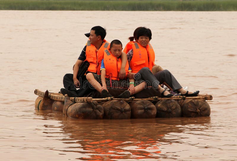 NINGXIA, CHINA - JUL 9, 2011: Tourists floating along the Yellow River Huang He on a sheepskin rafts. Balloons of these exotic rafts really made of sheep skin by locals. Shapotou Tourism area. NINGXIA, CHINA - JUL 9, 2011: Tourists floating along the Yellow River Huang He on a sheepskin rafts. Balloons of these exotic rafts really made of sheep skin by locals. Shapotou Tourism area