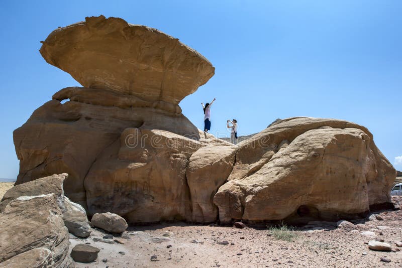 Los turistas toman las fotos en la roca de la seta en Wadi Rum en Jordania imagen de archivo libre de regalías Los turistas toman las fotos en la roca de la seta en Wadi Rum en Jordania imagen de archivo libre de regalías