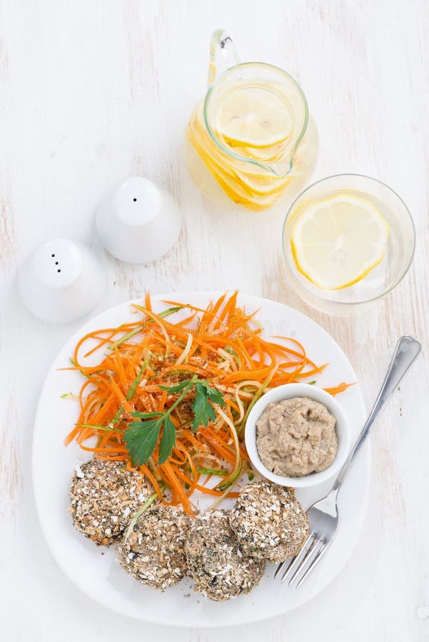 Los veganos almuerzan - las hamburguesas haba y ensalada de la zanahoria, visión superior imagen de archivo Los veganos almuerzan - las hamburguesas haba y ensalada de la zanahoria, visión superior imagen de archivo