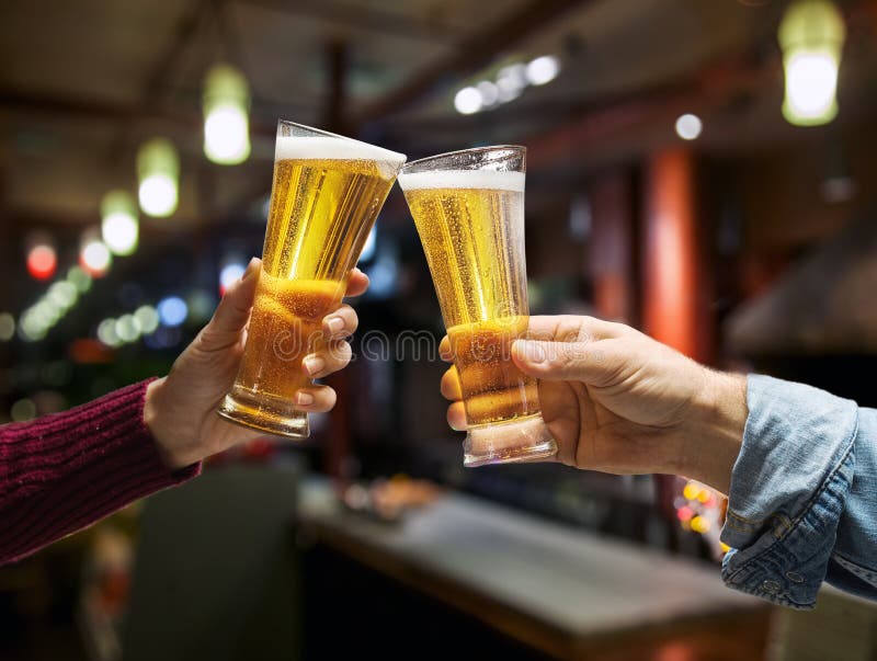 Los vidrios de cerveza aumentaron en manos de un primer de la tostada con los vidrios fotos de archivo Los vidrios de cerveza aumentaron en manos de un primer de la tostada con los vidrios fotos de archivo