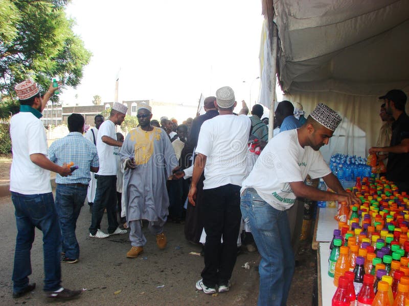 Los voluntarios musulmanes distribuyen el jugo foto de archivo Los voluntarios musulmanes distribuyen el jugo foto de archivo