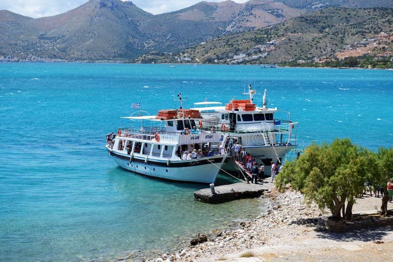 SPINALONGA, GREECE - MAY 14: The motor yachts with tourists are near Spinalonga island on May 14, 2014 in Spinalonga, Greece. Up to 16 mln tourists is expected to visit Greece in year 2014. SPINALONGA, GREECE - MAY 14: The motor yachts with tourists are near Spinalonga island on May 14, 2014 in Spinalonga, Greece. Up to 16 mln tourists is expected to visit Greece in year 2014.