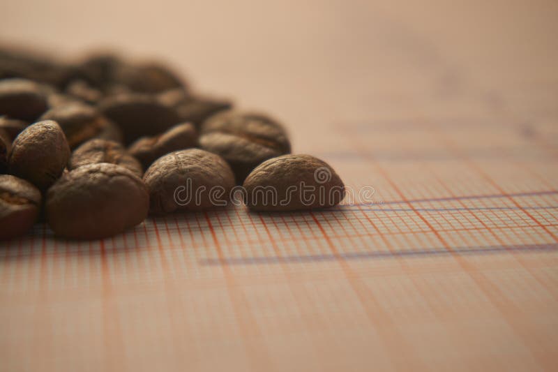 Lose Röstkaffeebohnen auf einer ECG-Verfolgung lizenzfreies stockfoto Lose Röstkaffeebohnen auf einer ECG-Verfolgung lizenzfreies stockfoto