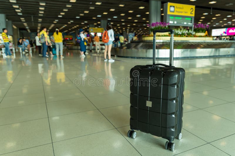 Lost black hardshell carry-on roller luggage left unattended at the baggage reclaim area at airport