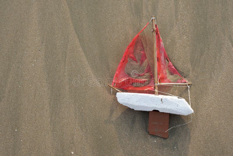 Lost toy boat washed up on beach from above