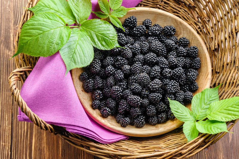 Lot of black raspberry in wooden bowl in basket