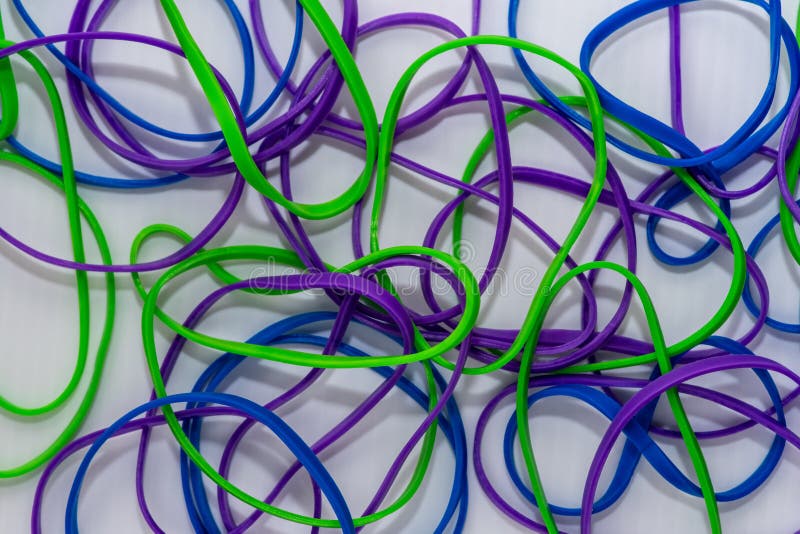 Colorful rubber bands on green background Stock Photo by