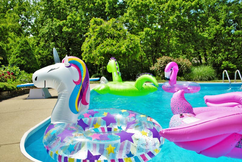 A lot of inflatables floating in a backyard swimming pool royalty free stock image