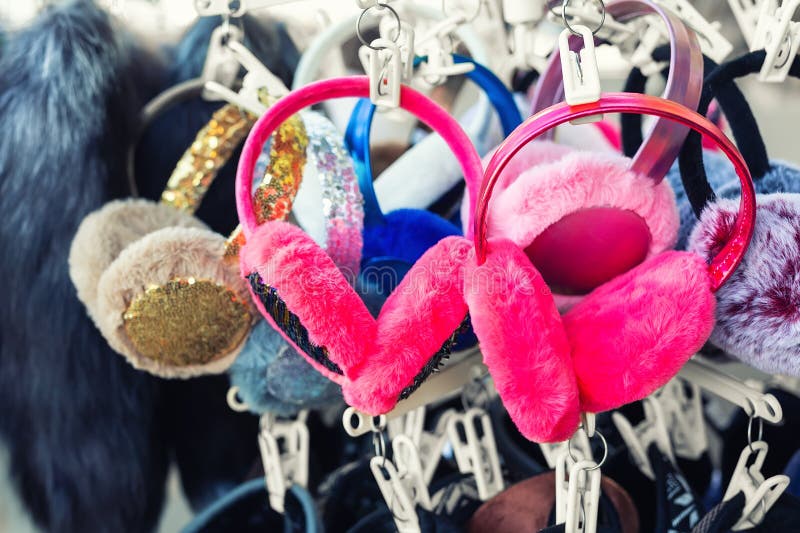 Lot of many multicolored bright fluffy fur earphones hanged on rack at store display for sale. Cute warm cold season clothes royalty free stock photography Lot of many multicolored bright fluffy fur earphones hanged on rack at store display for sale. Cute warm cold season clothes royalty free stock photography
