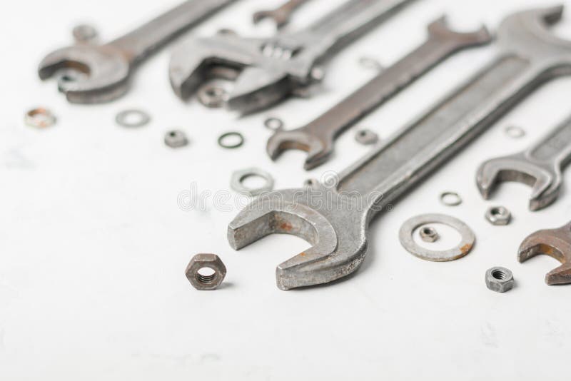 A lot of old wrenchs on a light stone background. Nuts and washers of different sizes. stock image
