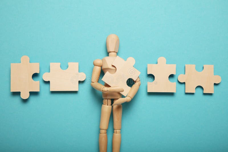 Lot of problems and depression, difficulty puzzles in hands of a wooden figure stock image Lot of problems and depression, difficulty puzzles in hands of a wooden figure stock image