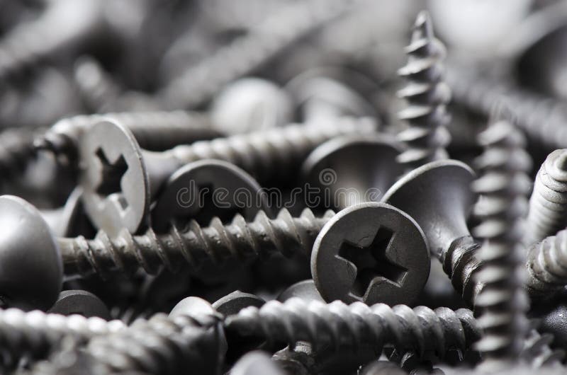 Lots of metal screws in close-up. Background of fixing tools. Macrophotography royalty free stock image