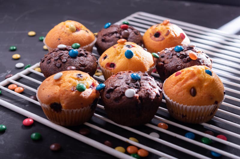 Lots of Muffins Sprinkled with Colored Sweets. Various Muffins on the