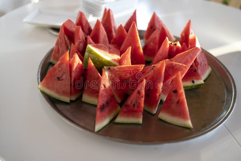 Lots of small triangular slices of ripe red watermelon on a plate. Isolated on white background. View from above. Triangular cut watermelon stock images, royalty-free photos and pictures