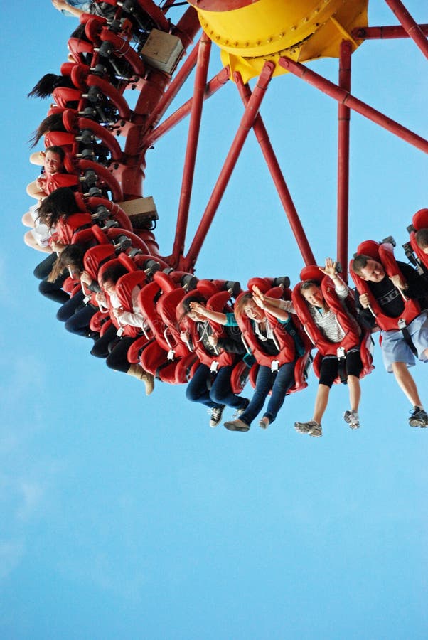 Lots of teenagers young people having fun on wild ride at theme park