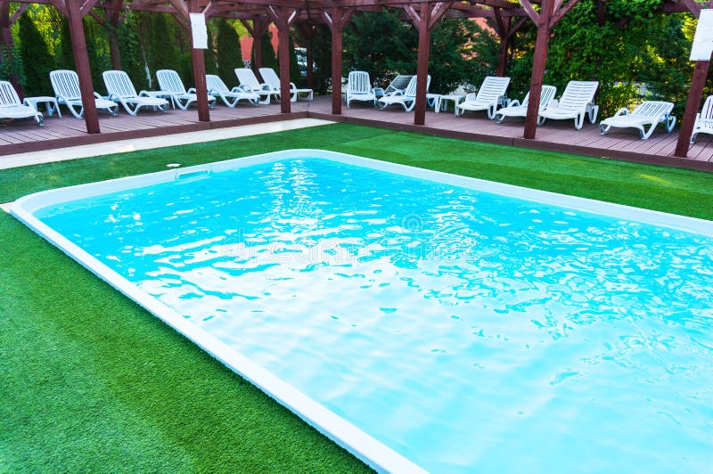 Lounge chairs near pool stock image. Image of laying - 51647211