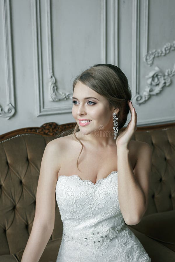 Louro de sorriso feliz da noiva no vestido de casamento Interior luxuoso imagem de stock Louro de sorriso feliz da noiva no vestido de casamento Interior luxuoso imagem de stock