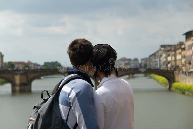 Young couple in love standing on bridge in Florence, Italy