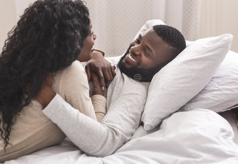 Portrait of romantic black couple spending time in bed together