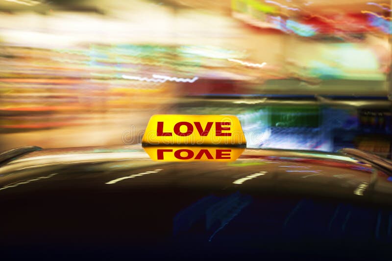 Love cab. Motion blurred conceptual image of a taxi sign on the roof of a car with the word Love on it royalty free stock photography Love cab. Motion blurred conceptual image of a taxi sign on the roof of a car with the word Love on it royalty free stock photography