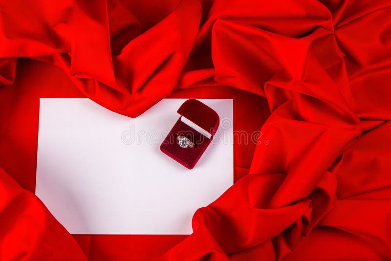 Love card with diamond ring on a red fabric. Love card. red jewel box with diamond ring on white paper and red fabric royalty free stock photos Love card with diamond ring on a red fabric. Love card. red jewel box with diamond ring on white paper and red fabric royalty free stock photos