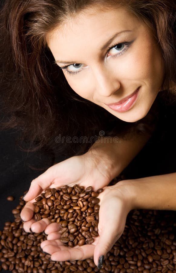 Mujer joven posesión granos de café en Rostro de corazón.