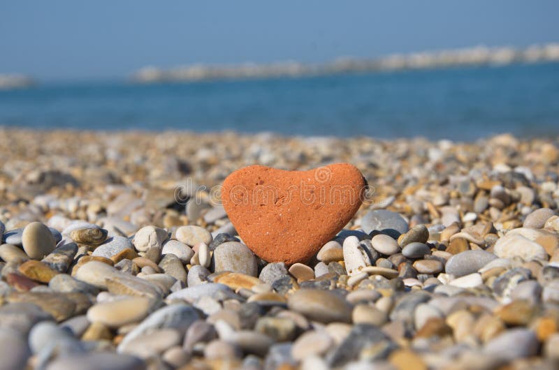 Love concept with a stone heart on pebbles