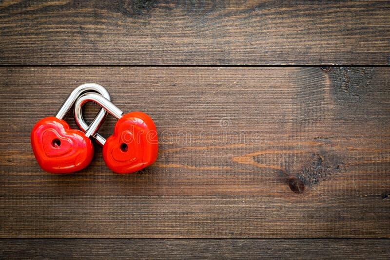 Love concept. Valentine`s day symbol. Locks in shape of heart o dark wooden background top view copy space stock photos Love concept. Valentine`s day symbol. Locks in shape of heart o dark wooden background top view copy space stock photos