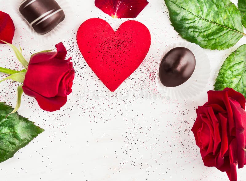 Love heart background with red roses and chocolate pralines