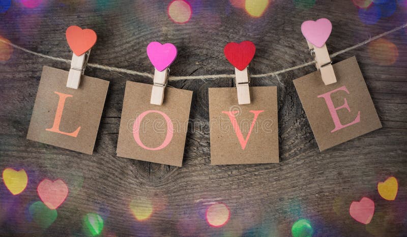 The love inscription and red heart clips hanging on natural cord for Valentine Day. royalty free stock images The love inscription and red heart clips hanging on natural cord for Valentine Day. royalty free stock images