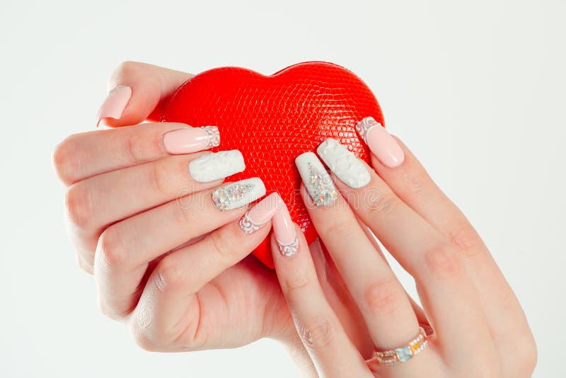 Love for manicure art concept. Beauty hands holding red heart shaped jewelry box. Stylish pastel Color pink coral white Nails isolated white background. Classic wedding bride nails design Nail Polish