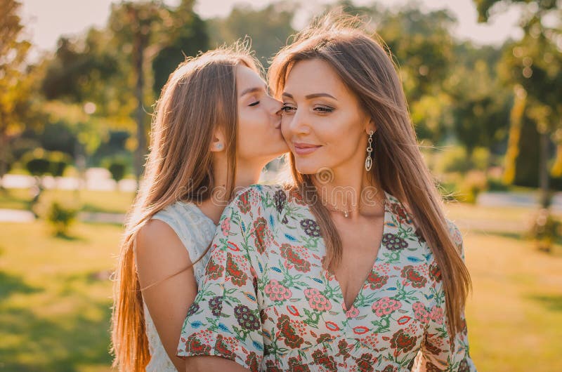 Happy Mother Son And Daughter In The Park Mom And Sister Kiss Thei