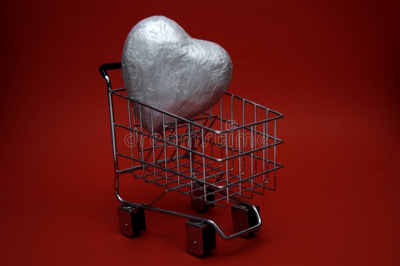 A large silver heart inside a shopping cart. Could represent a love for shopping or an attempt to buy love. A large silver heart inside a shopping cart. Could represent a love for shopping or an attempt to buy love.