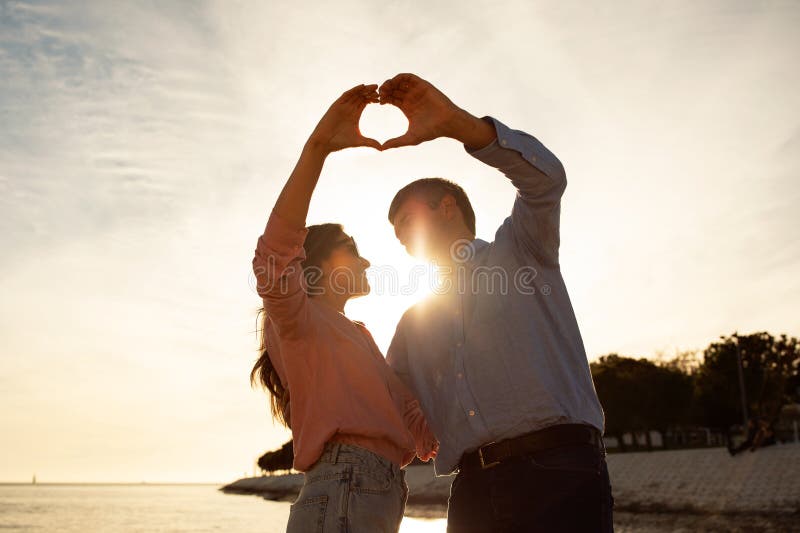 Youve Taught Me The True Meaning Of Love. A Couple Forming A Heart Shape  With Their Hands While Sitting On The Beach. Stock Photo, Picture and  Royalty Free Image. Image 198911221.