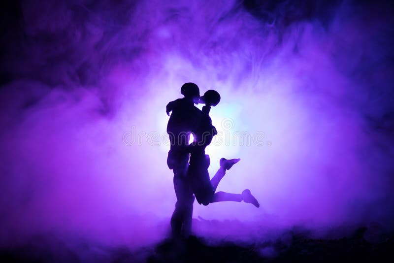 Love Valentine`s Day concept.Sillhouette of sweet young couple in love standing in the field and hugging on dark toned foggy backg royalty free stock photos Love Valentine`s Day concept.Sillhouette of sweet young couple in love standing in the field and hugging on dark toned foggy backg royalty free stock photos