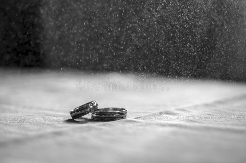 Love, Valentine`s day and wedding concept. Two wedding rings with man and woman hands blurred in the background. Selective focus stock photo Love, Valentine`s day and wedding concept. Two wedding rings with man and woman hands blurred in the background. Selective focus stock photo