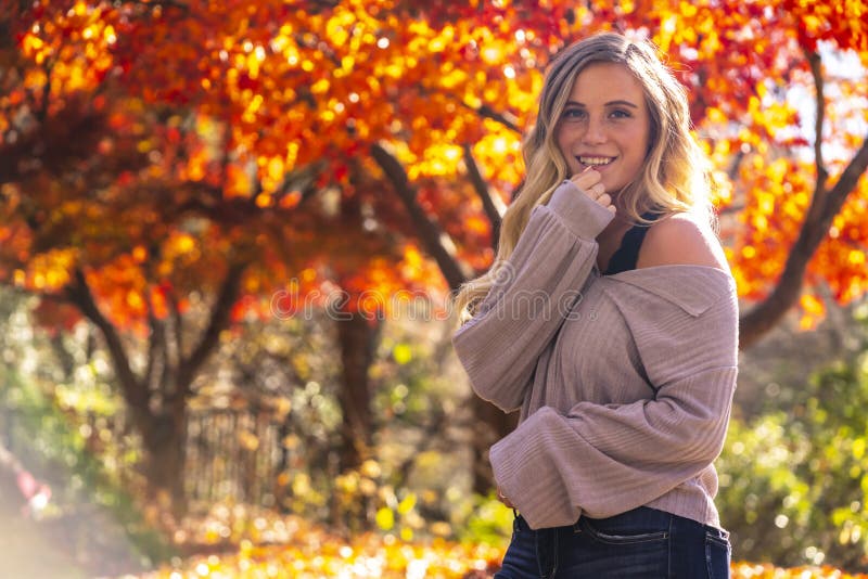 A Lovely Blonde Model Enjoys An Autumn Day Outdoors At The Park Stock