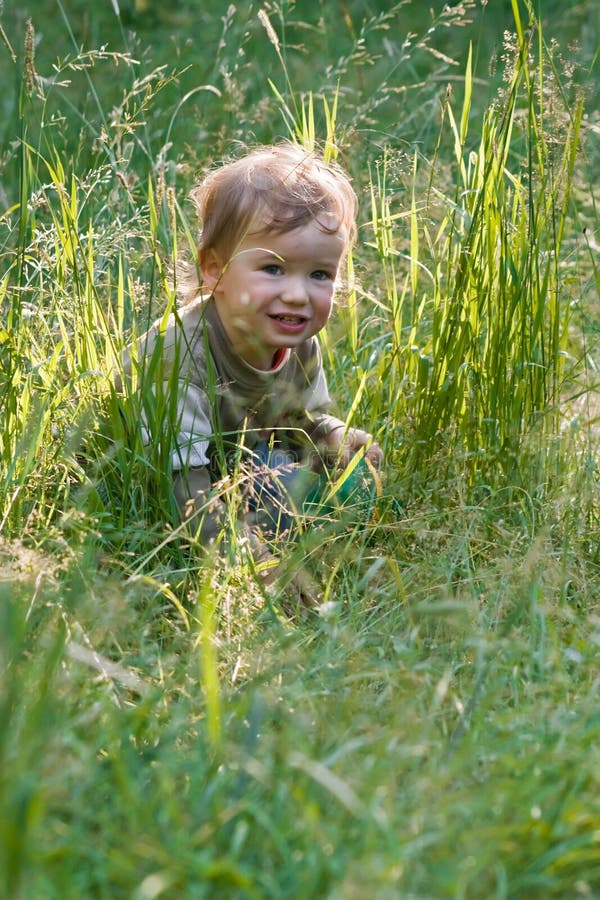 Lovely child plays to a grass royalty free stock photo Lovely child plays to a grass royalty free stock photo