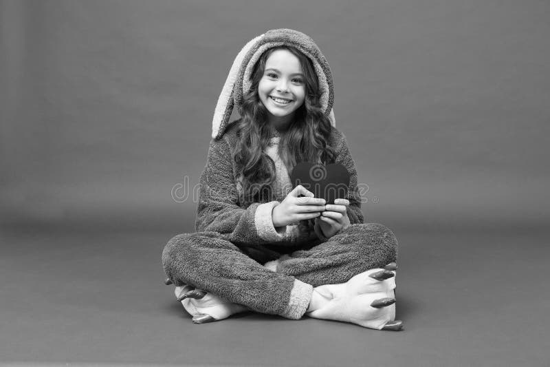 Lovely child. Rest and relax. Cute bunny kid. Baby animal character. Girl in bunny costume funny slippers. Child rabbit. Kigurumi. Happy girl bunny pajamas royalty free stock photography Lovely child. Rest and relax. Cute bunny kid. Baby animal character. Girl in bunny costume funny slippers. Child rabbit. Kigurumi. Happy girl bunny pajamas royalty free stock photography