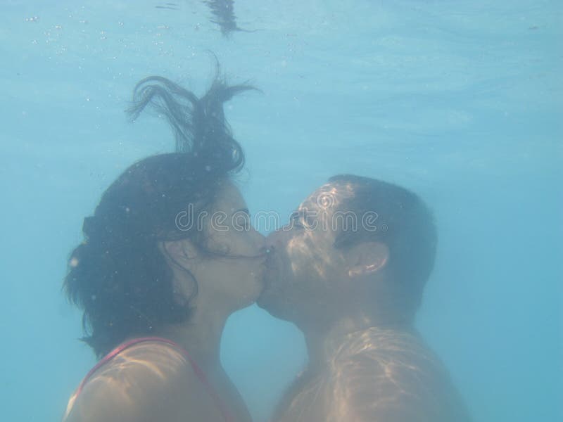 Bella coppia bacio sott'acqua in una piscina.