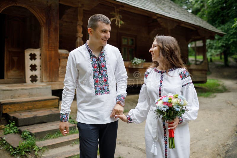 Beautiful bride and groom in the ukrainian style are standing w. Lovely cou...